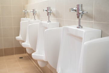 Empty row of urinals men and boy at the public toilet.White ceramic urinals for man in the gentleman rest room.
