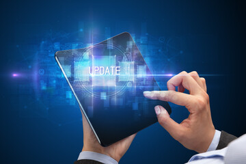 Businessman holding a foldable smartphone with UPDATE inscription, new technology concept