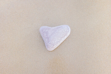 Heart shaped pebble on the sand beach