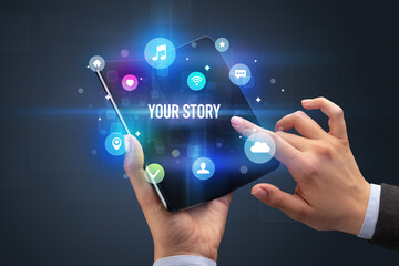 Businessman holding a foldable smartphone with YOUR STORY inscription, social media concept