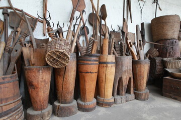many different old things household items:  spinning wheel, stupas, shovels.