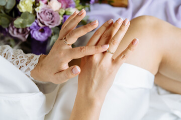 Obraz na płótnie Canvas Wedding white manicure. Women's hands with a wedding ring