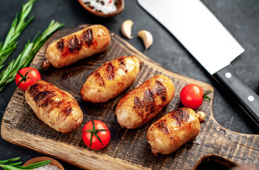 
Grilled sausages with spices and
rosemary served on a cutting board on a stone background