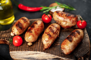 
Grilled sausages with spices and
rosemary served on a cutting board on a stone background