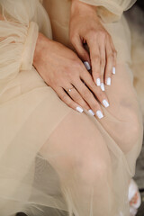 Wedding white manicure. Women's hands with a wedding ring