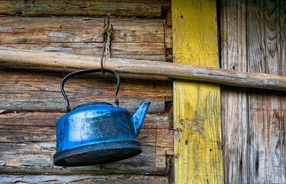 Old lost broken kettle on wooden wall
