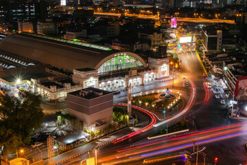 Illuminated main train station by night with traffic lights