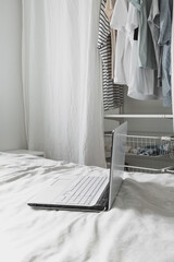 basic women's clothes on a hanger and blurred notebook , open wardrobe with textile curtains close-up