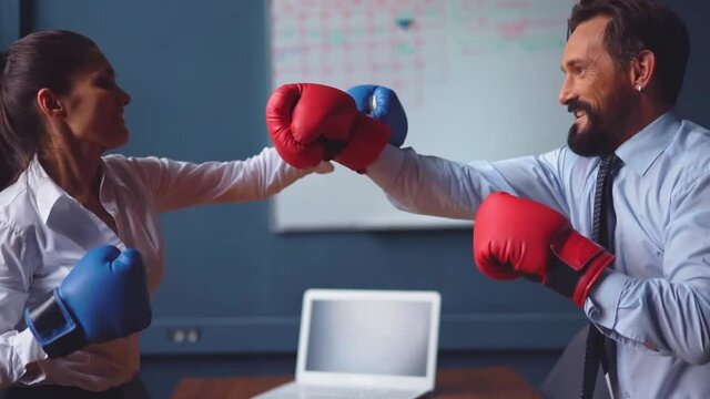Business people boxing fighting wearing gloves. Man and a woman in business clothes are trying hard to release stressful situations making funny fight. Gender Conflict Concept. Prores 422. 