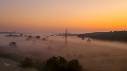 Obraz na płótnie Canvas High voltage electricity transfer lines and pylon in a fog