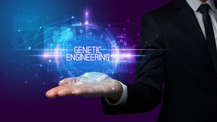 Man hand holding GENETIC ENGINEERING inscription, technology concept