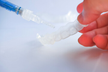 Hand holding teeth tray for dental whitening opalescence, silicone tray for more whitening teeth