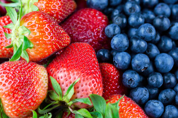 A close up view of strawberries and blueberries.