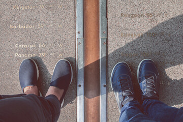 Pairs of legs stand on either side of the Prime Meridian - obrazy, fototapety, plakaty