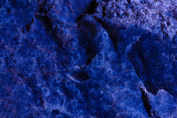 The blue stone was taken close-up. Texture, background. Cracks and relief. Photo, image.