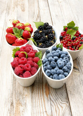 Variety of fresh berries in bowls, vertical