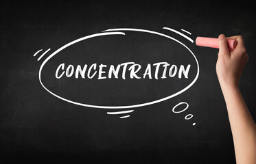 Hand drawing CONCENTRATION inscription with white chalk on blackboard, education concept