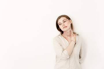 Obraz premium a girl in a shirt touches her bruises, stands on a white background, the victim of domestic violence, left the place for advertising