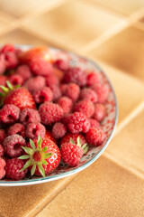Assiette de fraises et de framboises fraîches dans une cuisine