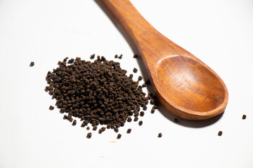 Dried Tea Leaves powder on Spoon With White Background