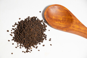 Dried Tea Leaves powder on Spoon With White Background
