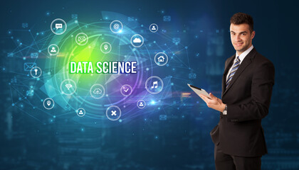 Businessman thinking in front of technology related icons and DATA SCIENCE inscription, modern technology concept