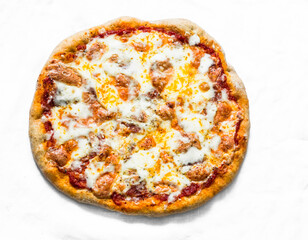 Salami sausage, mozzarella, tomato pizza on a light background, top view