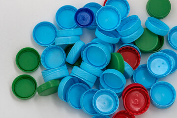 Color covers for plastic bottles with drink on white background. Red, blue and green plastic covers.