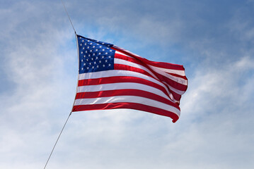 Raising a large American flag on a windy day.