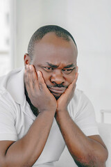 Fototapeta premium Loss of a loved one. Grief in the family. Death of a child. Sad face depressed elderly african man. Very sad elderly man. Concept of loneliness and pain.