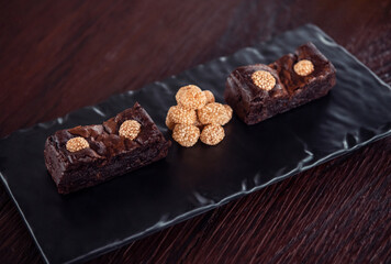 Chocolate brownies with sesame balls or Klepon, Kelepon, Onde Onde- traditional Southeast Asian rice cake balls. Asian modern dessert
