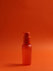 cosmetic flacon bottle on the orange