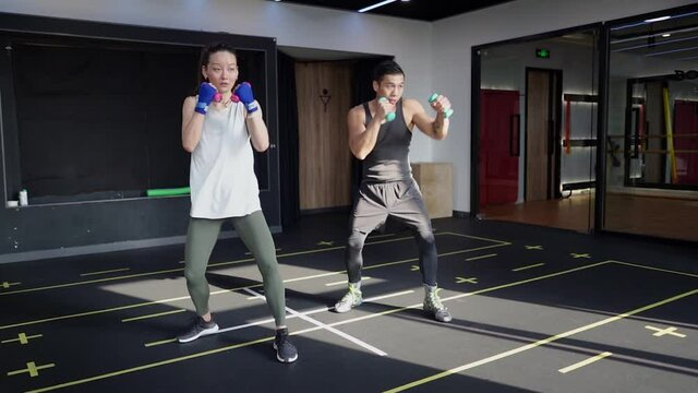 Boxing With Trainer Weighted Punches.  Asian Man And Woman Shadowboxing Using Weights For Fitness And Practice In Gym. 