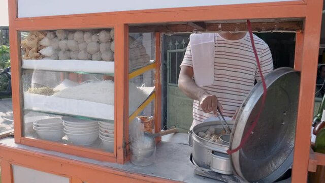man selling bakso in the carts. indonesia street food vendor. small business entrepreneur