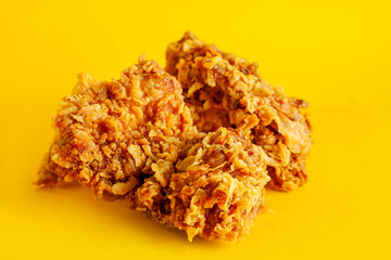 Crispy fried chicken against a bright yellow background