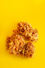 Crispy fried chicken against a bright yellow background