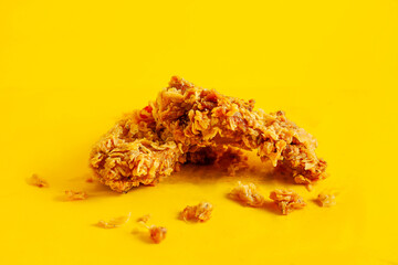 Crispy fried chicken against a bright yellow background