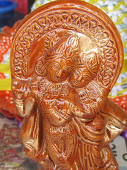 CLOSE UP OF AN INDIAN  WOODEN ART OF A TINY STATUE OF LORD KRISHNA 