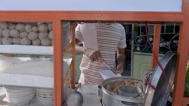 bakso. indonesian famous meatball street food vendor close up hand serving