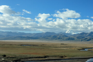 First view on Kailash Mountain rising from Barkha plain from the road from the distance with fields in front
