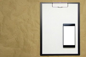 The tablet with a clip for the clip of paper with a white sheet a4. Above is a mobile phone with a white screen. Place for text, copy space and layout for design