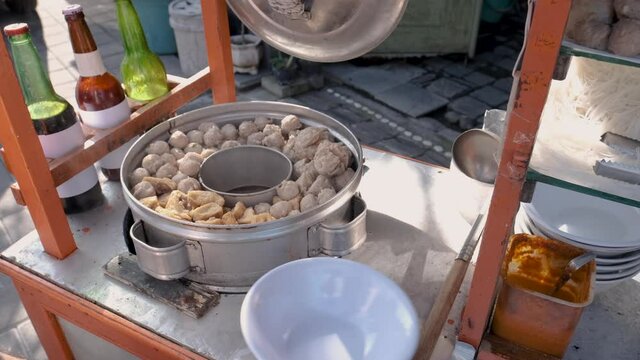 bakso. indonesian famous meatball street food vendor close up hand serving