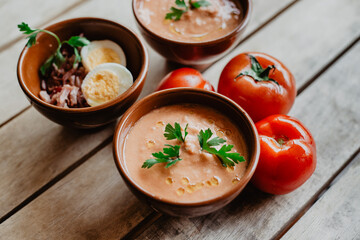 clay bowls with Andalusian gazpacho, along with some tomatoes, parsley, chopped egg, and Iberian ham