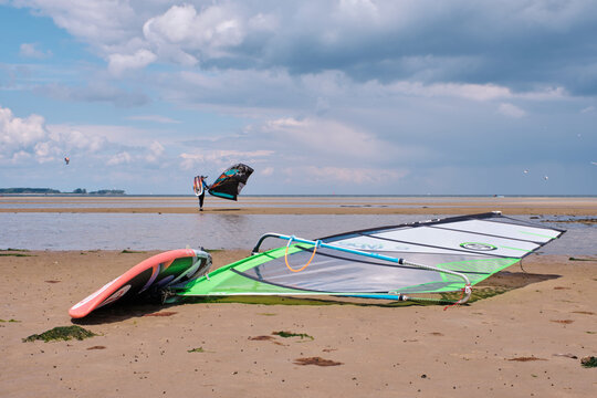 windsurfer board with kitesurfing in the background