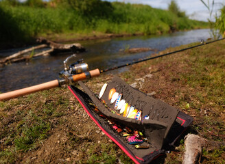 Trout fishing tackle on the river bank