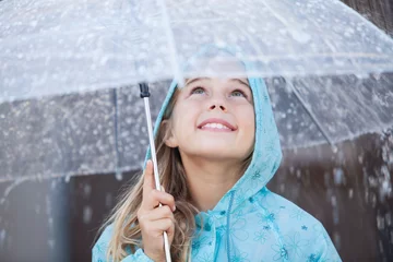 Fotobehang Close up of smiling girl under umbrella in downpour © Chris Ryan/KOTO