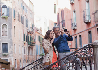 Fototapeta na wymiar Smiling couple taking photograph in Venice