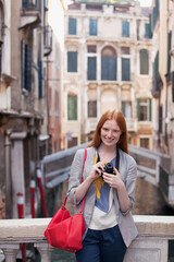 Portrait of smiling woman with camera in Venice