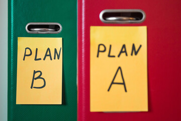 Priority of plan b, instead of a. Two folders with notes on stickers. Business planning. A spare option. Difficulties of enterprise management. Decision making. Foreground in blur.