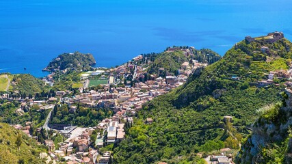 Fototapeta na wymiar Aerial view of Taormina, on right is Castello Saraceno, in center is Ancient Greek theatre. Taormina located on Sicily island in Italy.